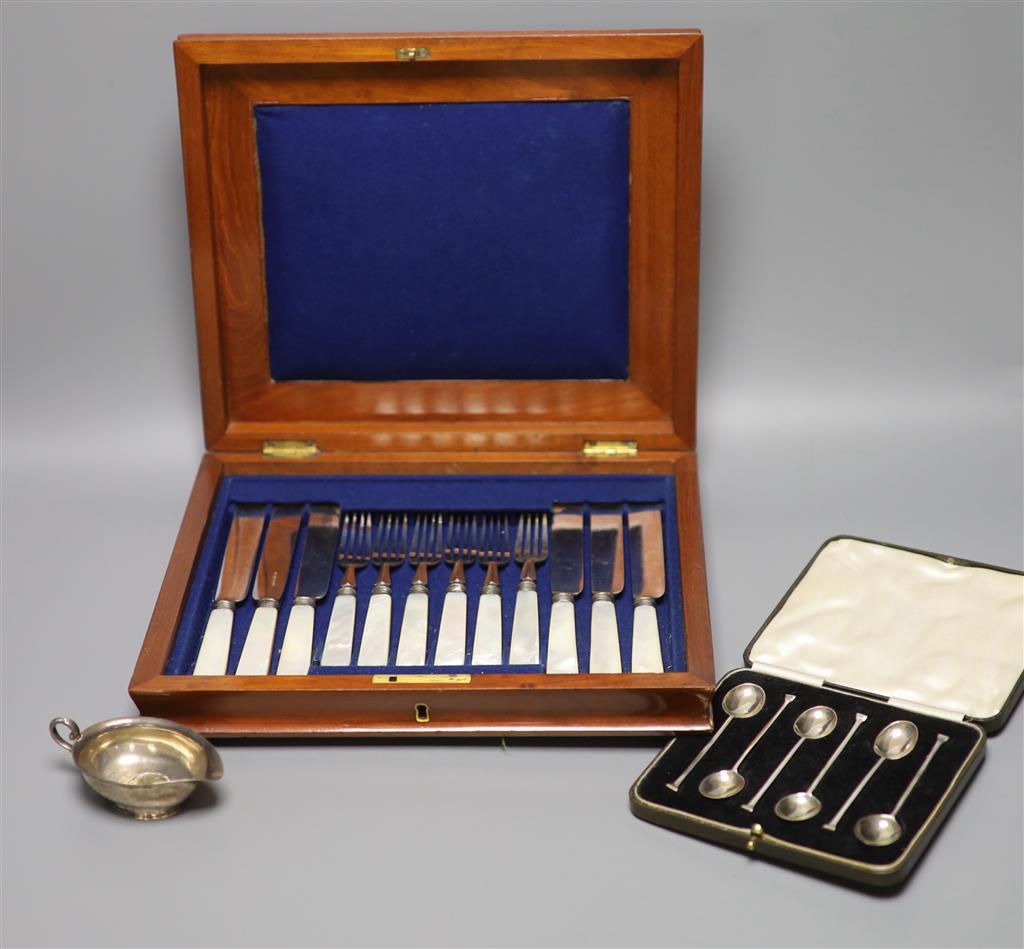 A cased set of plated mother of pearl handled cutlery, a cased set of six silver coffee spoons and a cream jug with inset Queen Anne co